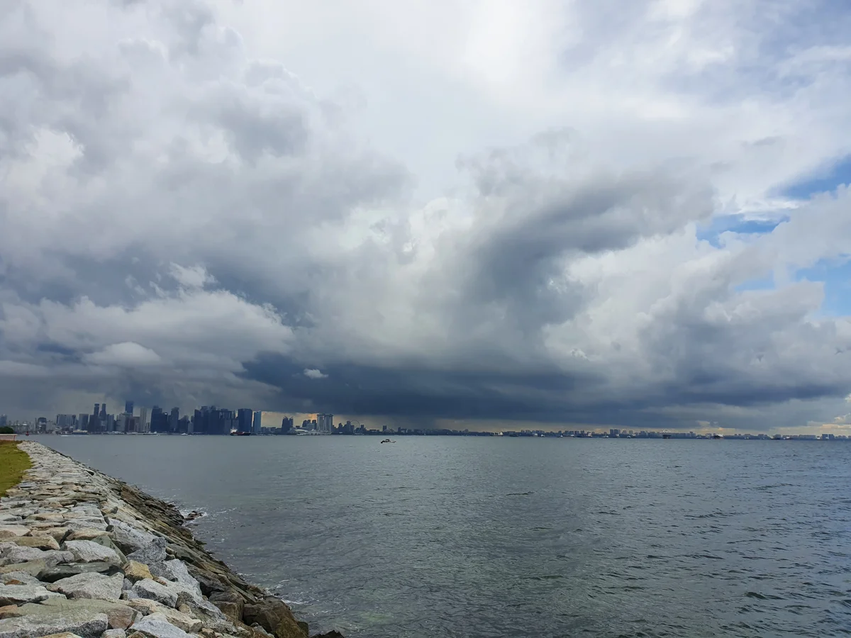 while I stand watching distant rain over Marina Bay.
